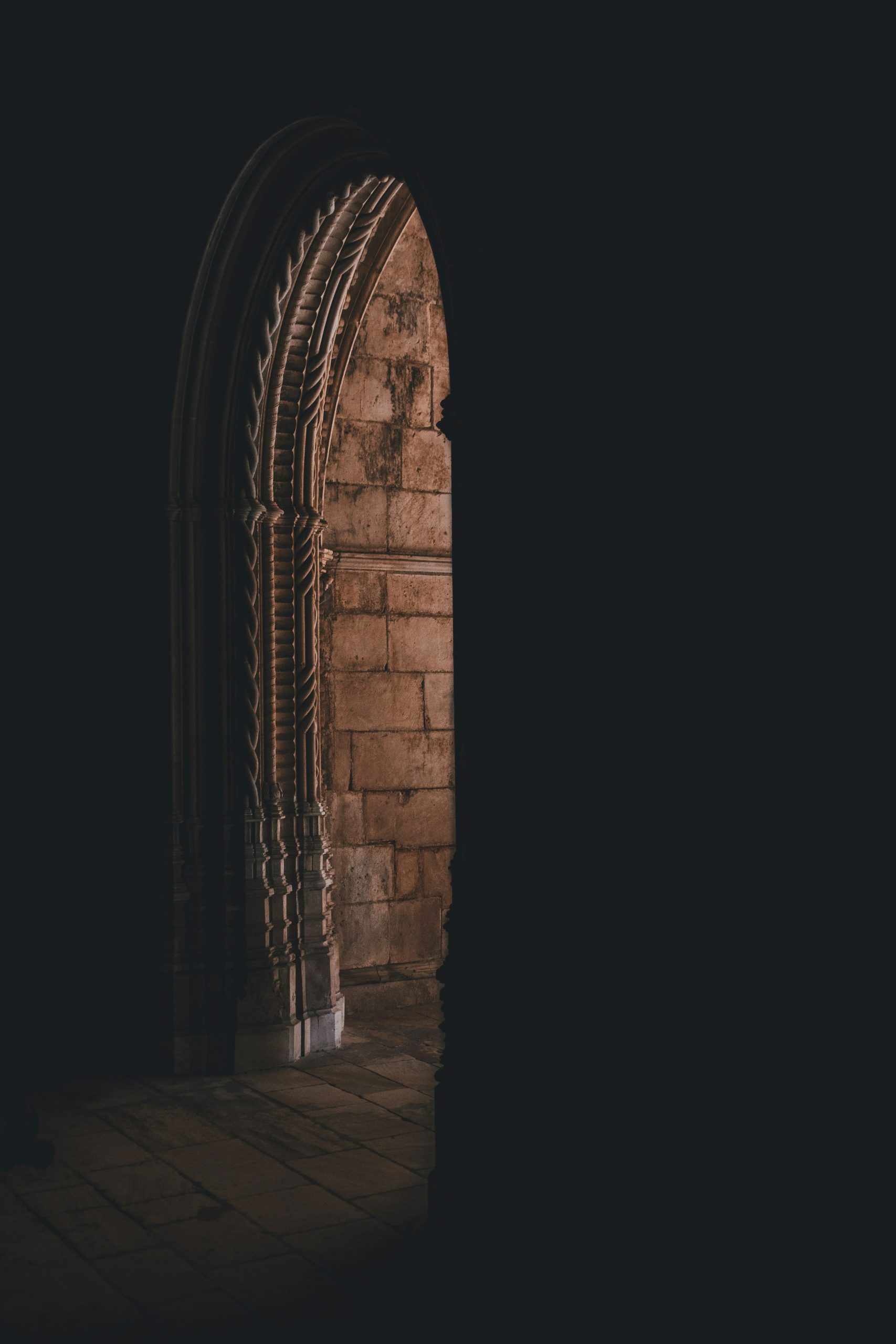 Candlelit corridor with stone arches